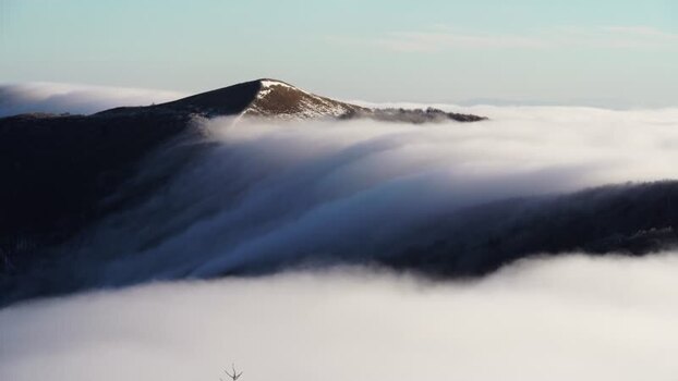 View of Balkan Mountains peak above sea of clouds in Bulgaria.