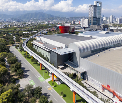 Aerial view of the modern convention center and monorail track at Fundidora Park with the urban skyline and mountains in the background in Monterrey Nuevo Leon Mexico. Aerial view of the modern convention center and monorail track at Fundidora Park with the urban skyline and mountains in the background in Monterrey Nuevo Leon Mexico.