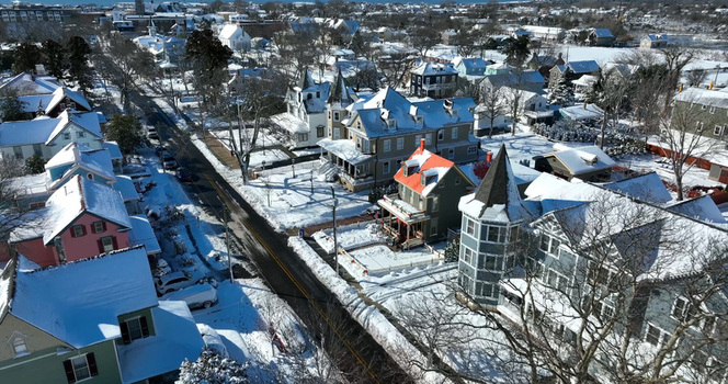 Aerial view of historic Victorian houses covered in snow along a quiet street in Cape May New Jersey United States.