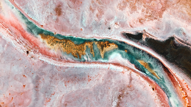 Aerial view of vibrant salt evaporation ponds with colorful mineral deposits and salt crusts in Fremont California United States.