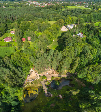 Aerial view of a lush green park featuring stone pathways small ponds and surrounding forest in Latvia. Aerial view of a lush green park featuring stone pathways small ponds and surrounding forest in Latvia.