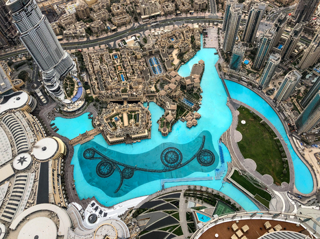View of the Dubai Fountain and surrounding modern skyscrapers with turquoise water and urban architecture in Dubai Dubai United Arab Emirates. View of the Dubai Fountain and surrounding modern skyscrapers with turquoise water and urban architecture in Dubai Dubai United Arab Emirates.