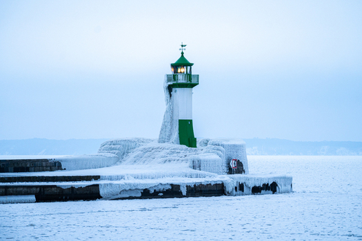 View of the frozen Molenfeuer Sassnitz lighthouse surrounded by ice and snow on a pier in the Baltic Sea Sassnitz Mecklenburg Vorpommern Germany.