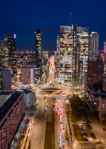 Aerial view of the illuminated skyscrapers and busy urban traffic at the Rondo ONZ roundabout in the city center of Warsaw at night Poland. Aerial view of the illuminated skyscrapers and busy urban traffic at the Rondo ONZ roundabout in the city center of Warsaw at night Poland.