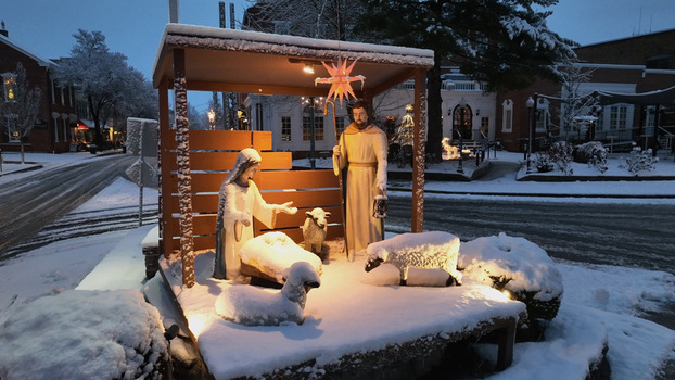 Aerial view of a snow covered nativity scene with figures of Mary and Joseph surrounded by sheep in a town square at dawn in Lititz Pennsylvania United States. Aerial view of a snow covered nativity scene with figures of Mary and Joseph surrounded by sheep in a town square at dawn in Lititz Pennsylvania United States.