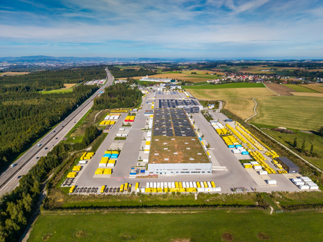 Aerial view of Logistikzentrum Allhaming with a large warehouse solar panels and parking areas filled with yellow trucks near a highway in Allhaming Oberosterreich Austria. Aerial view of Logistikzentrum Allhaming with a large warehouse solar panels and parking areas filled with yellow trucks near a highway in Allhaming Oberosterreich Austria.