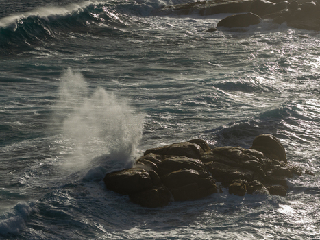 Aerial view of powerful ocean waves crashing against dark coastal rocks with sea spray and sunlight reflecting on the water Torndirrup Western Australia Australia. Aerial view of powerful ocean waves crashing against dark coastal rocks with sea spray and sunlight reflecting on the water Torndirrup Western Australia Australia.