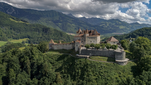 Gruyeres Switzerland 14 May 2026 Aerial view of Chateau de Gruyeres surrounded by lush green forests and the majestic Swiss Alps under a cloudy sky. Gruyeres Switzerland 14 May 2026 Aerial view of Chateau de Gruyeres surrounded by lush green forests and the majestic Swiss Alps under a cloudy sky.