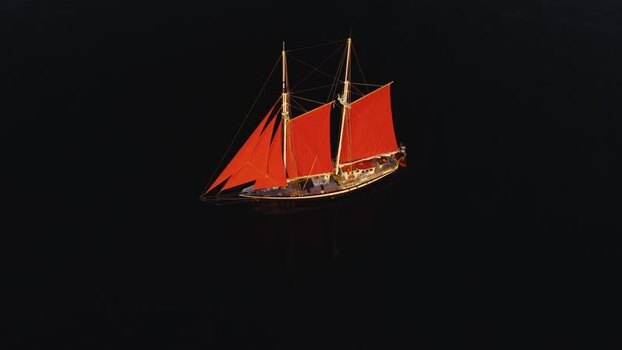 Aerial view of a sailboat with red sails in Greenland. Aerial view of a sailboat with red sails in Greenland.