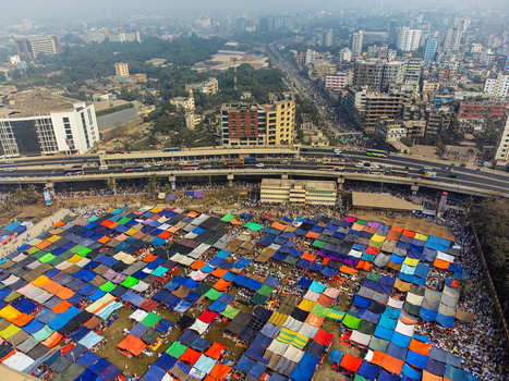 Tongi Bangladesh 31 January 2025 Aerial view of Tongi Ijtema Maidan featuring a vast expanse of colorful tents packed with crowds of people situated near a busy highway and urban cityscape.