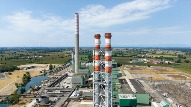 Aerial view of the TTEP Tavazzano thermal power plant and TERNA electrical substation with tall chimneys and industrial facilities in Tavazzano con Villavesco Lombardy Italy.