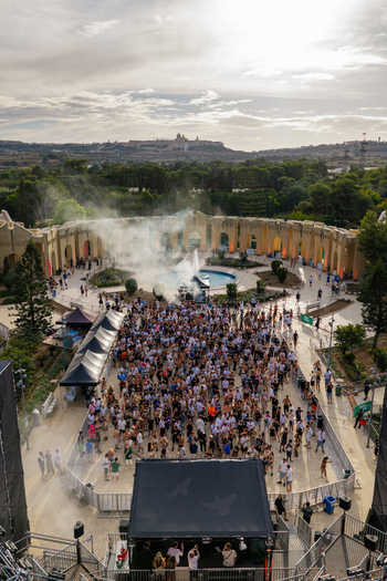 Aerial view of a large crowd gathered at an outdoor music event in Park Nazzjonali Ta Qali with a stage and smoke effects in Attard Northern Region Malta. Aerial view of a large crowd gathered at an outdoor music event in Park Nazzjonali Ta Qali with a stage and smoke effects in Attard Northern Region Malta.