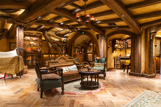 View of cozy interior awash with warm light rustic wooden beams and rich textures inviting armchairs Hobbiton Movie Set Waikato Region New Zealand. View of cozy interior awash with warm light rustic wooden beams and rich textures inviting armchairs Hobbiton Movie Set Waikato Region New Zealand.
