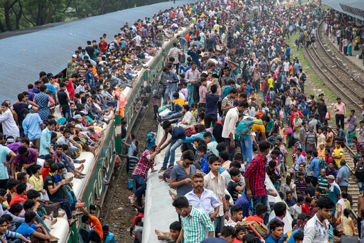 Dhaka Bangladesh 15 June 2018 View of a massive crowd of people sitting on the roofs of trains at Airport Railway Station during the Eid holiday rush. Dhaka Bangladesh 15 June 2018 View of a massive crowd of people sitting on the roofs of trains at Airport Railway Station during the Eid holiday rush.