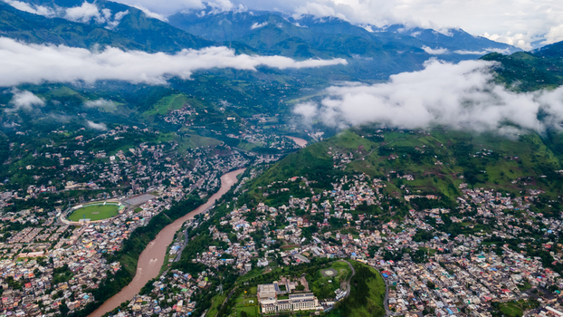 Aerial view of the urban landscape of Muzaffarabad nestled in a mountain valley with a winding river and low hanging clouds Muzaffarabad Azad Kashmir Pakistan. Aerial view of the urban landscape of Muzaffarabad nestled in a mountain valley with a winding river and low hanging clouds Muzaffarabad Azad Kashmir Pakistan.