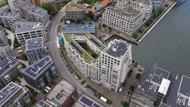 Aerial view of modern residential apartment buildings with green roofs and solar panels situated along the waterfront in the Cruquiusweg area of Amsterdam Noord Holland Netherlands.