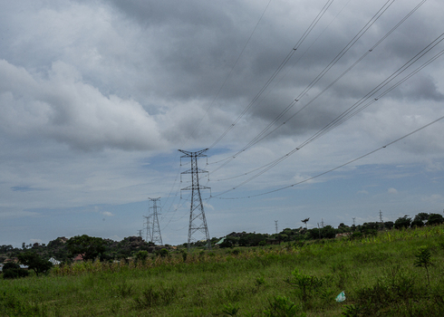 View of electricity transmission towers standing in a grassy landscape under a cloudy sky in Jos Plateau Nigeria. View of electricity transmission towers standing in a grassy landscape under a cloudy sky in Jos Plateau Nigeria.