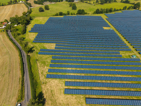 Aerial view of Lisburn Solar Farm with rows of photovoltaic panels set in green fields and surrounded by rural countryside in Lisburn Northern Ireland United Kingdom. Aerial view of Lisburn Solar Farm with rows of photovoltaic panels set in green fields and surrounded by rural countryside in Lisburn Northern Ireland United Kingdom.