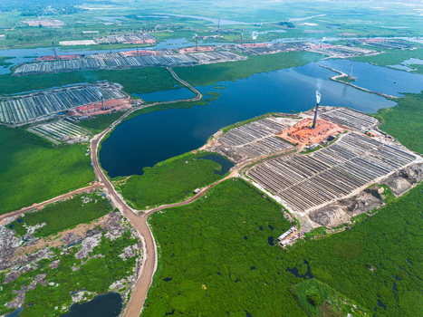 Aerial view of industrial brick kilns rise amidst a verdant landscape contrasting with the dark waters of the surrounding ponds Dhaka Dhaka Division Bangladesh. Aerial view of industrial brick kilns rise amidst a verdant landscape contrasting with the dark waters of the surrounding ponds Dhaka Dhaka Division Bangladesh.