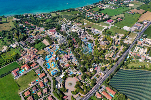 Aerial view of Gardaland Park featuring roller coasters and water attractions surrounded by lush greenery near Lake Garda in Ronchi Veneto Italy. Aerial view of Gardaland Park featuring roller coasters and water attractions surrounded by lush greenery near Lake Garda in Ronchi Veneto Italy.