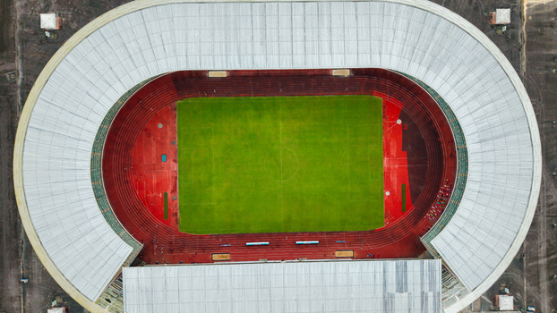 Aerial view of Godswill Akpabio Stadium featuring a vibrant green football pitch surrounded by a red running track and expansive white roof structure in Uyo Akwa Ibom Nigeria. Aerial view of Godswill Akpabio Stadium featuring a vibrant green football pitch surrounded by a red running track and expansive white roof structure in Uyo Akwa Ibom Nigeria.