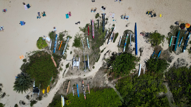 Aerial view of kayaks and people scattered across the white sands of Lanikai Beach contrasting with the lush green vegetation Kailua Hawaii United States. Aerial view of kayaks and people scattered across the white sands of Lanikai Beach contrasting with the lush green vegetation Kailua Hawaii United States.