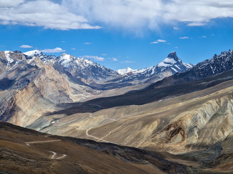 View of the Penzi La road winding through the rugged snow capped Himalayan mountain landscape of Zanskar Ladakh India.