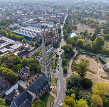 Aerial view of St Mary s Church in Stoke Newington featuring its tall spire surrounding historic buildings lush green trees and urban streets in London England United Kingdom.