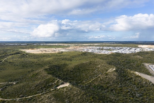 Aerial view of a residential development surrounded by native bushland and rolling hills under a cloudy sky in Perth Western Australia Australia. Aerial view of a residential development surrounded by native bushland and rolling hills under a cloudy sky in Perth Western Australia Australia.