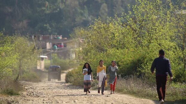 View of three young women walking on a dusty road in Dhangadhi Nepal. View of three young women walking on a dusty road in Dhangadhi Nepal.