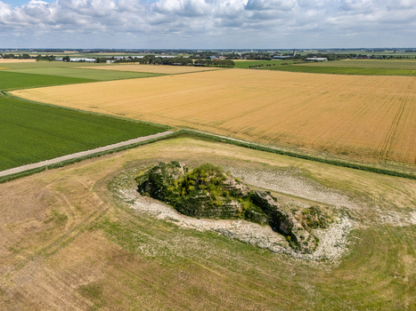 Aerial view of the Dijk van een wijf sculpture situated in a rural field surrounded by agricultural farmland under a bright sky in Oosterbierum Friesland Netherlands. Aerial view of the Dijk van een wijf sculpture situated in a rural field surrounded by agricultural farmland under a bright sky in Oosterbierum Friesland Netherlands.