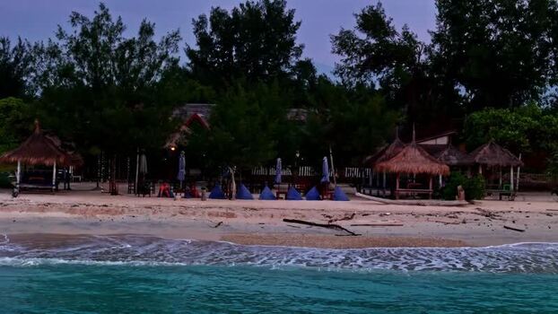 Aerial view of beach huts and bean bags on the shore Indonesia.