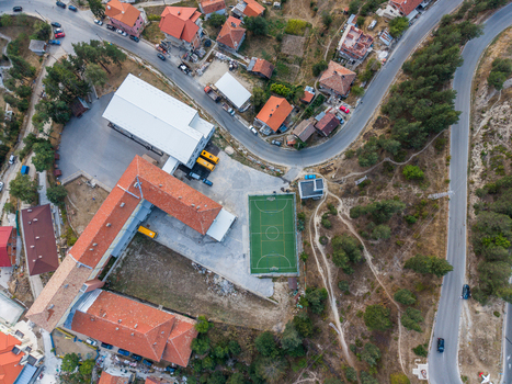 Aerial view of a school building complex with a sports court surrounded by houses trees and winding roads in Sveta Petka Pazardzhik Bulgaria. Aerial view of a school building complex with a sports court surrounded by houses trees and winding roads in Sveta Petka Pazardzhik Bulgaria.