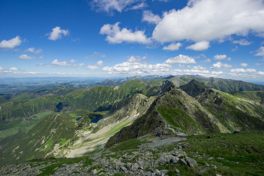 View of Tri kopy in Western Tatras with rocky ridges green slopes and mountain lakes under a blue sky with white clouds in Ziar Zilina Region Slovakia. View of Tri kopy in Western Tatras with rocky ridges green slopes and mountain lakes under a blue sky with white clouds in Ziar Zilina Region Slovakia.