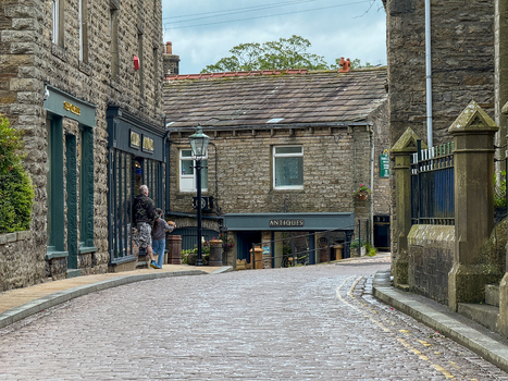 Hawes United Kingdom 05 July 2025 View of a cobblestone street lined with historic stone buildings and an antique shop in the Yorkshire Dales. Hawes United Kingdom 05 July 2025 View of a cobblestone street lined with historic stone buildings and an antique shop in the Yorkshire Dales.