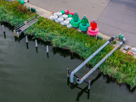 Aerial view of Rijkswaterstaat Harderhaven featuring navigation buoys industrial pipes and waterfront infrastructure in Zeewolde Flevoland Netherlands.