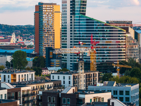 Aerial view of modern skyscrapers and construction cranes rising above residential buildings in Vilnius Vilnius County Lithuania. Aerial view of modern skyscrapers and construction cranes rising above residential buildings in Vilnius Vilnius County Lithuania.