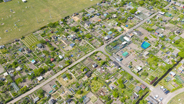 Aerial view of Amateur Gardeners Association Het Kloosterpark featuring allotment gardens with small sheds and green plots in De Bilt Utrecht Netherlands.