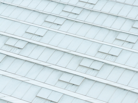 Aerial view of a production scale greenhouse with glass panels and ventilation hatches in Poland.