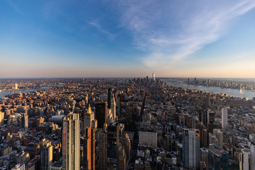 New York New York United States 09 August 2021 Aerial view of the Manhattan skyline at sunset featuring One World Trade Center dense urban architecture and surrounding waterways.