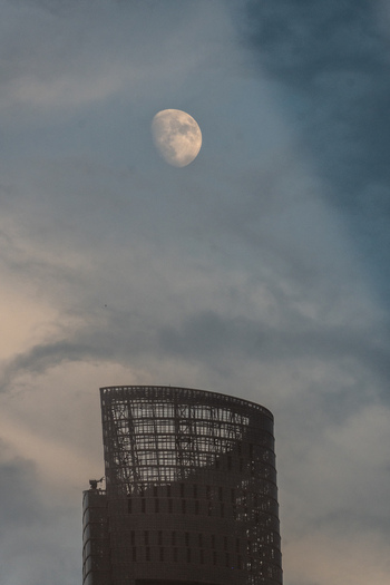 Aerial view of the Lujiazui skyscraper with the moon visible in the cloudy sky above Shanghai Shanghai China.