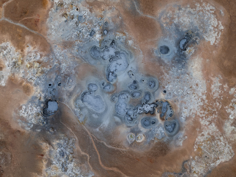 Aerial view of Hverir geothermal area featuring bubbling mud pots and colorful mineral deposits in the volcanic landscape of Reykjahlid Thingeyjarsveit Iceland. Aerial view of Hverir geothermal area featuring bubbling mud pots and colorful mineral deposits in the volcanic landscape of Reykjahlid Thingeyjarsveit Iceland.