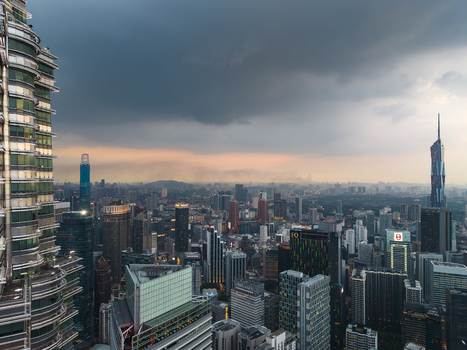 Kuala Lumpur Malaysia 11 March 2026 Aerial view of the Petronas Twin Towers and Merdeka 118 skyscraper overlooking the city skyline under a dramatic stormy sky at dusk.