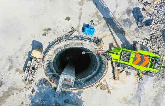 Aerial view of a deep circular construction shaft with a green crane and heavy machinery on a dusty site in Avcilar Istanbul Turkey. Aerial view of a deep circular construction shaft with a green crane and heavy machinery on a dusty site in Avcilar Istanbul Turkey.
