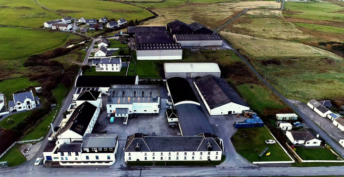Islay Scotland United Kingdom 30 September 2026 Aerial view of the Bruichladdich Distillery complex with white buildings and dark roofs surrounded by green fields.