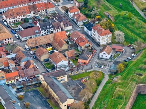 Aerial view of the quaint buildings nestled within the star shaped fortress walls a tapestry of russet roofs and verdant ramparts Neuf Brisach Grand Est France.