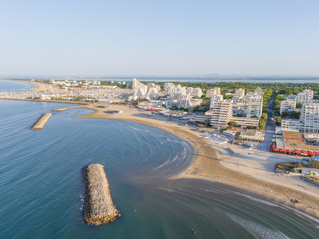 Aerial view of the pyramid shaped buildings along the sandy beach and Mediterranean coastline in La Grande Motte Occitanie France.