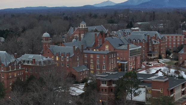 Aerial view of the red brick buildings of Liberty University campus with snow covered grounds and mountains in the distance in Lynchburg Virginia United States.