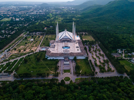 Aerial view of the iconic Faisal Masjid with its white marble structure and four tall minarets nestled against the lush green Margalla Hills Islamabad Islamabad Capital Ter Pakistan. Aerial view of the iconic Faisal Masjid with its white marble structure and four tall minarets nestled against the lush green Margalla Hills Islamabad Islamabad Capital Ter Pakistan.