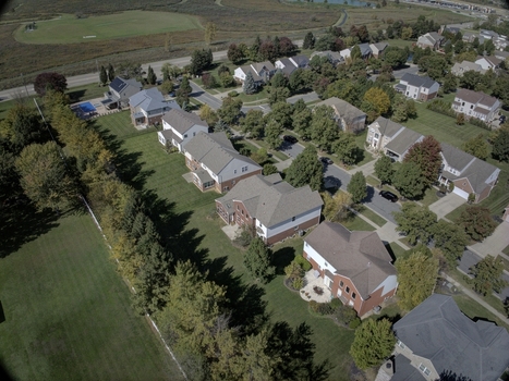 Aerial view of a suburban residential neighborhood with detached houses manicured lawns tree lined streets and a nearby golf course in Mason Ohio United States.
